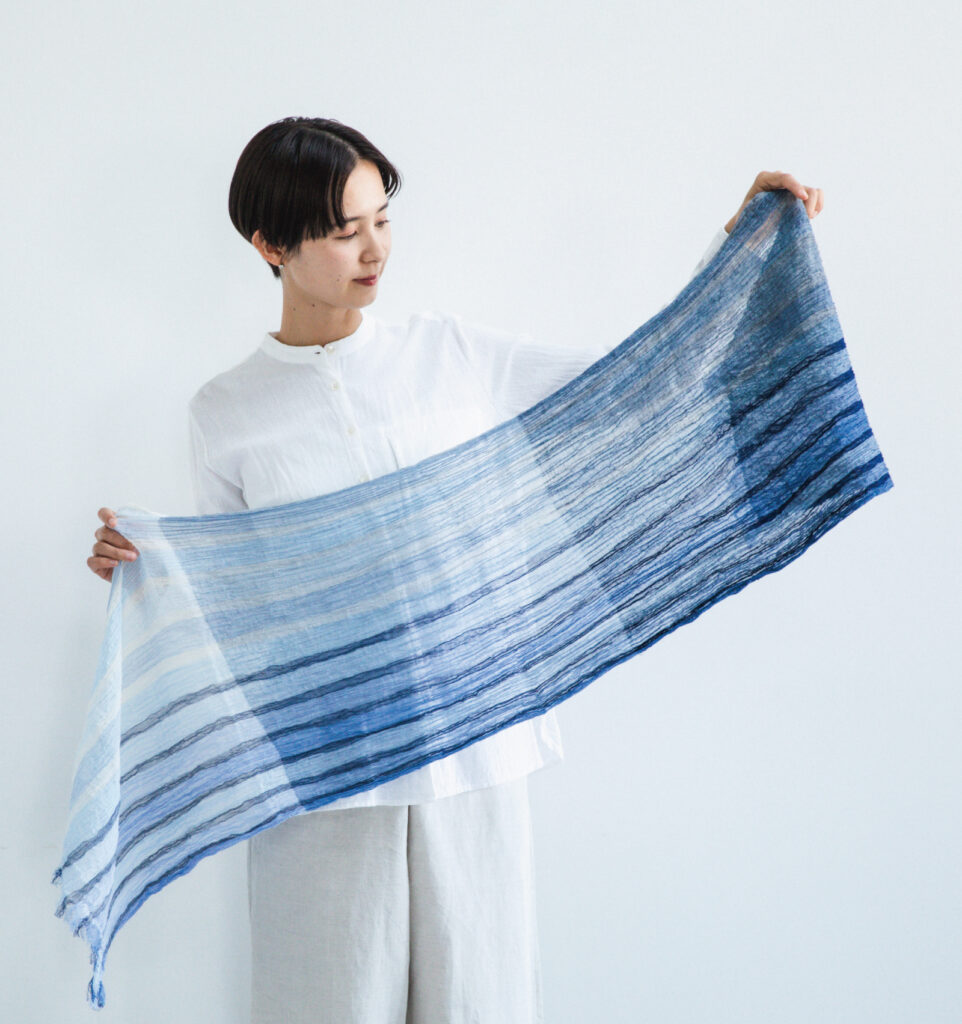 KUSHU リネンコットンスト―ル サックスストライプ 手に持つつ様子の画像